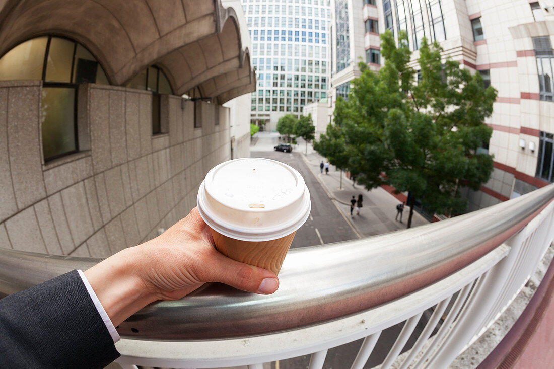 Businessman holding disposable coffee cup