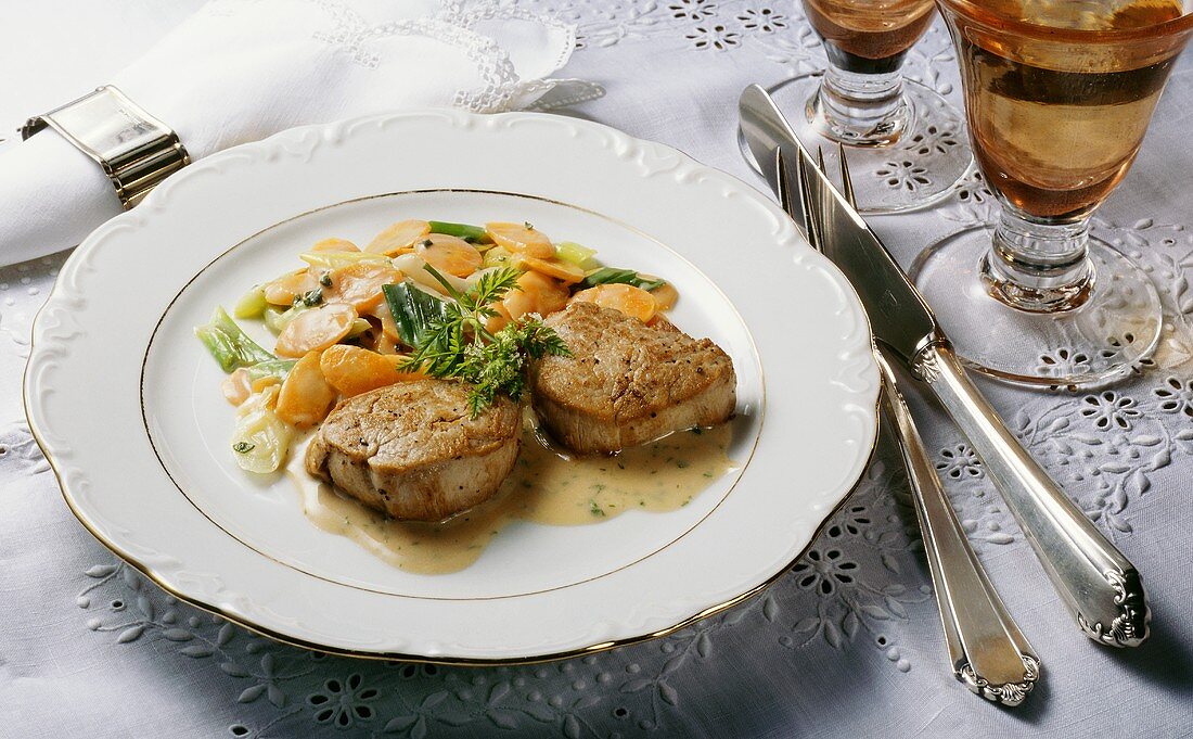 Veal medallions with carrots and leeks on plate