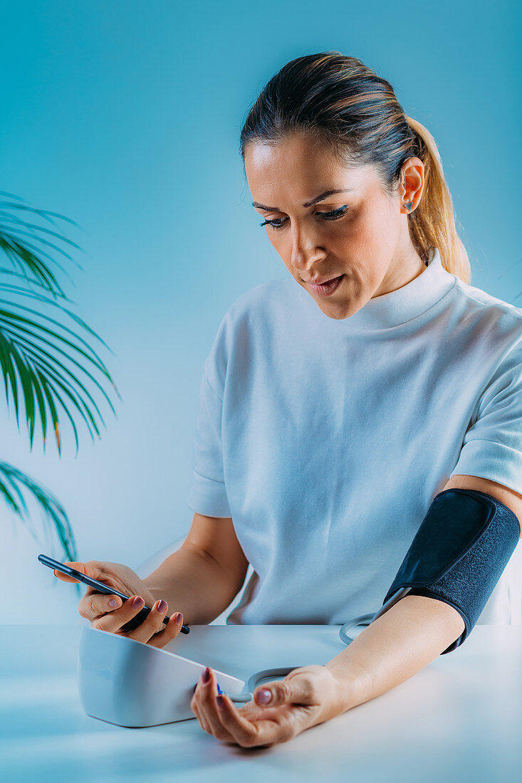 Woman entering blood pressure data in smart phone