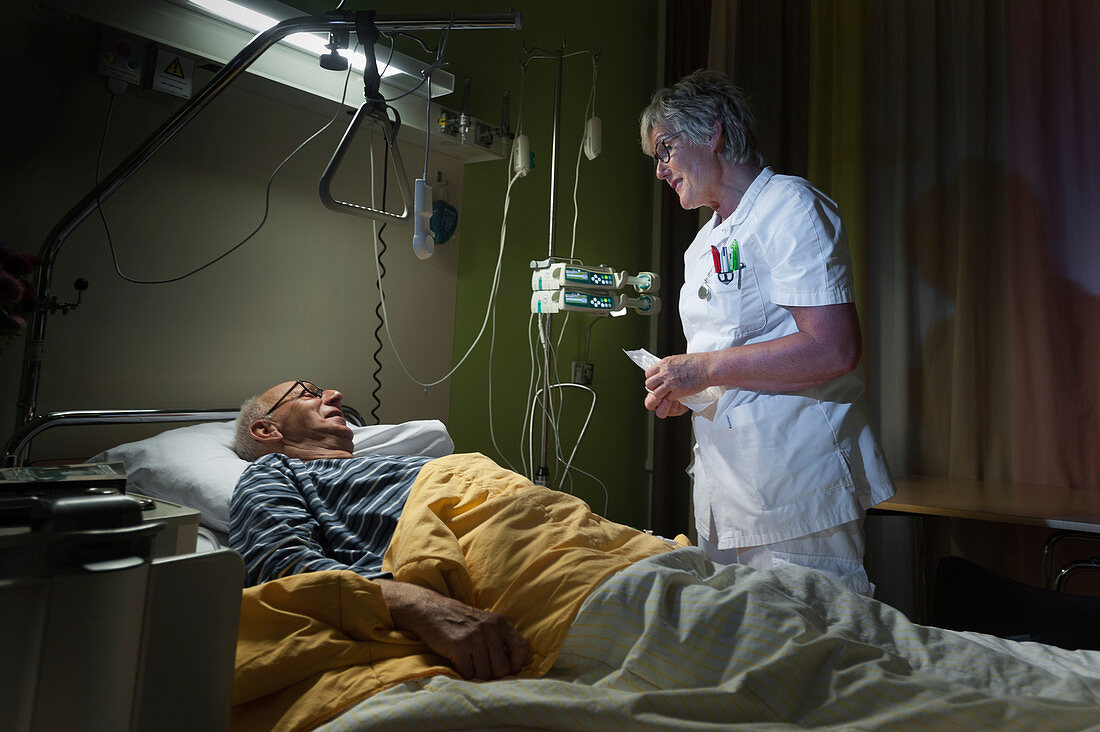 Nurse checking on patient on palliative care ward