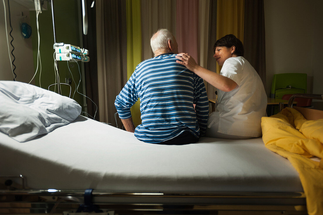 Nurse talking to patient on palliative care ward