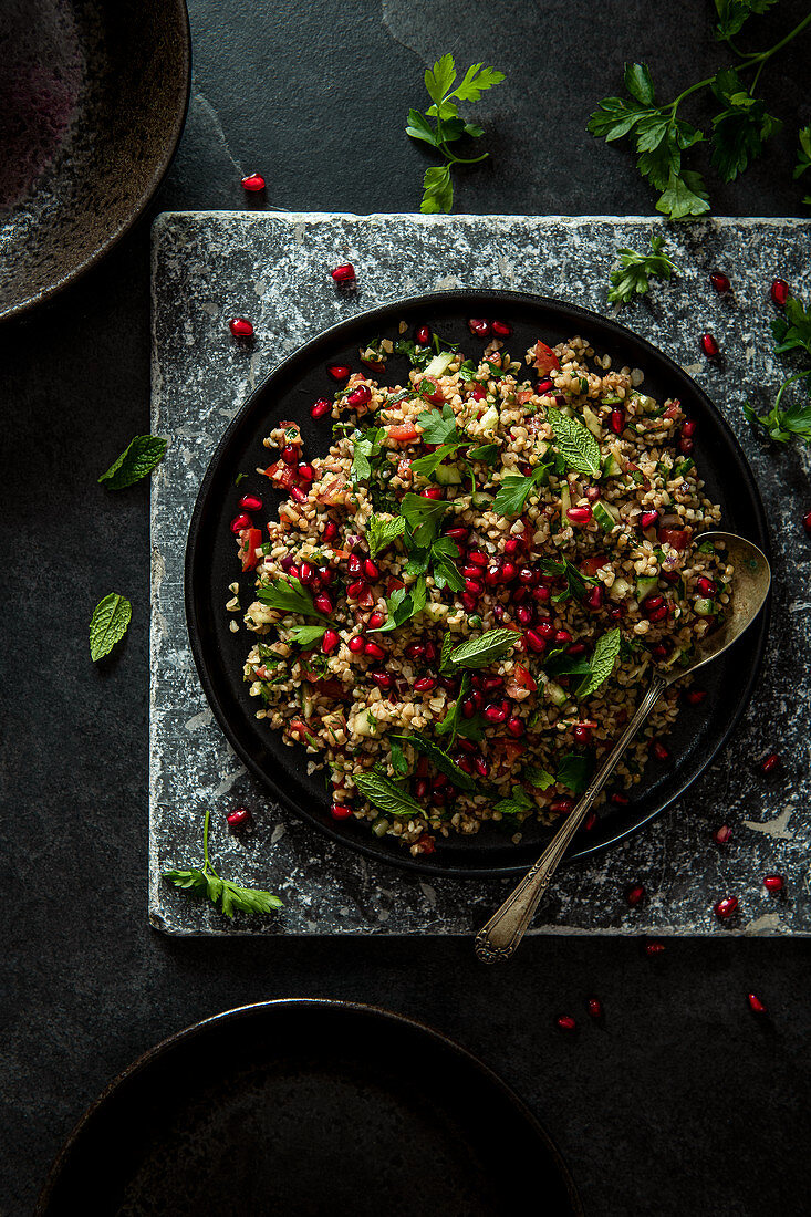 Middle eastern tabbouleh salad with bulgar wheat, parsley, mint, tomatoes and pomegranate seeds