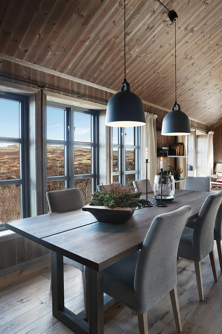 Esstisch im Cottage vor Sprossenfensterfront mit imposanten Landschaftsblick