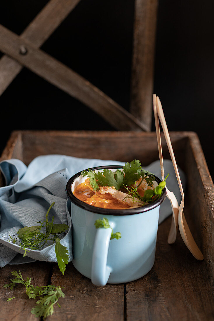Tomato soup in a cup with wooden spoons