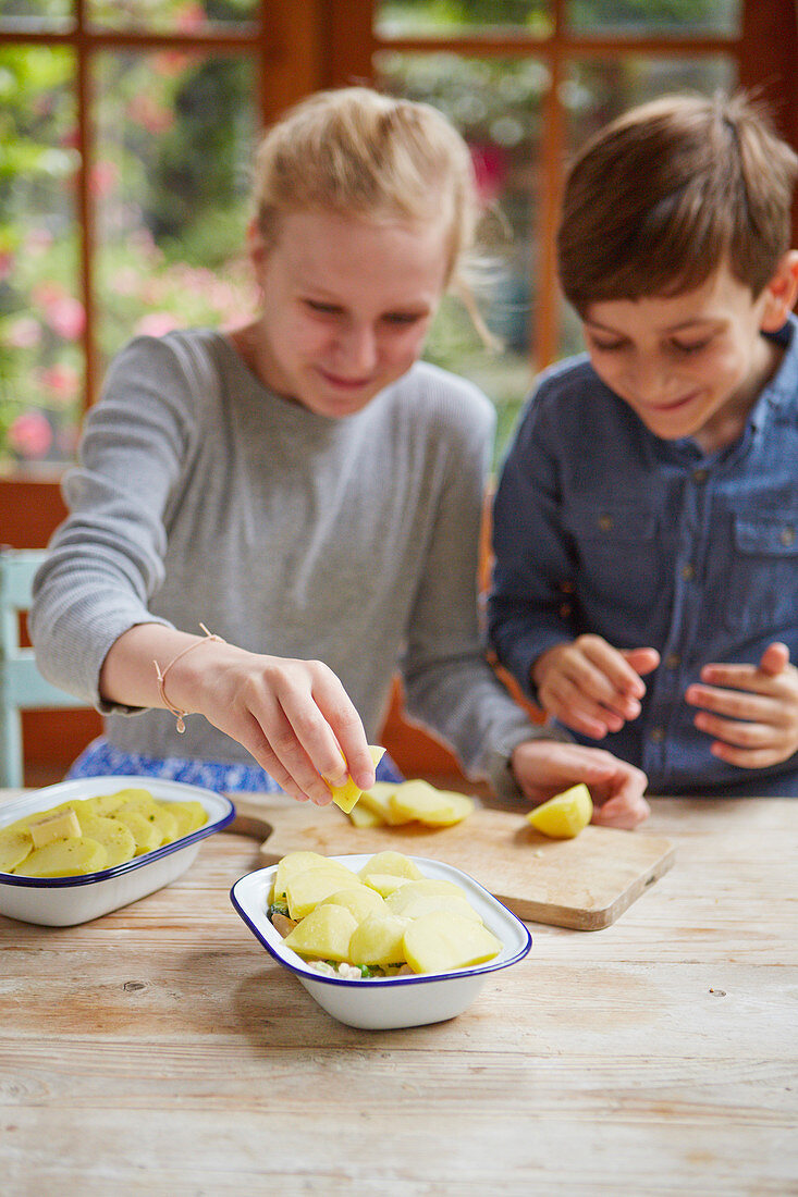 Kinder bereiten Kartoffelgratin zu
