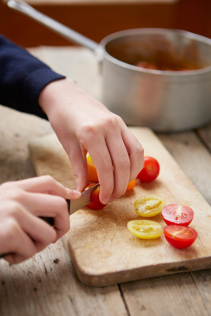 Kid cutting cherry tomatoes