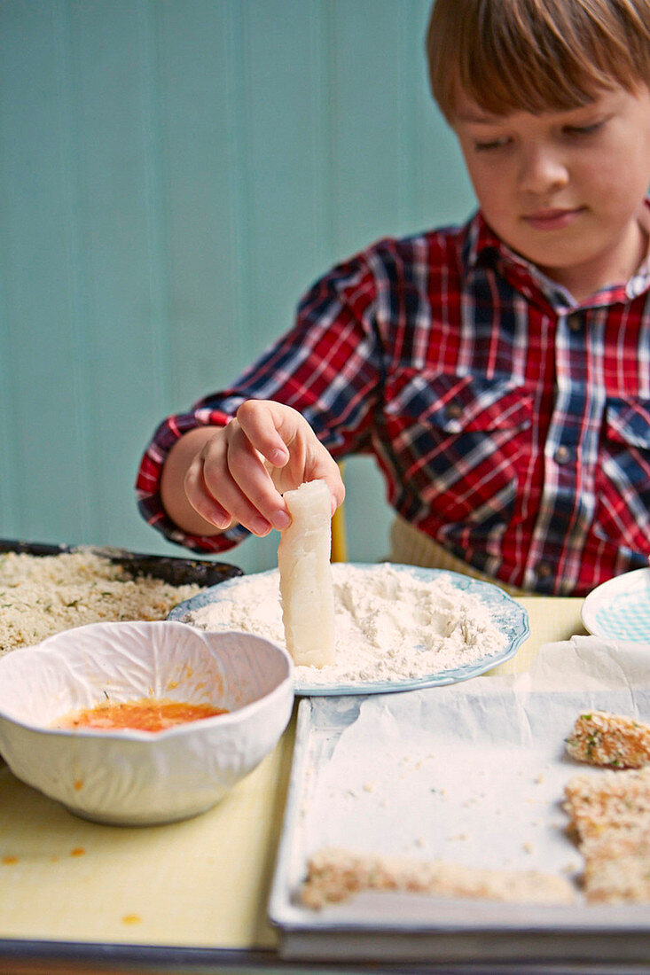 Boy preparing fish fingers