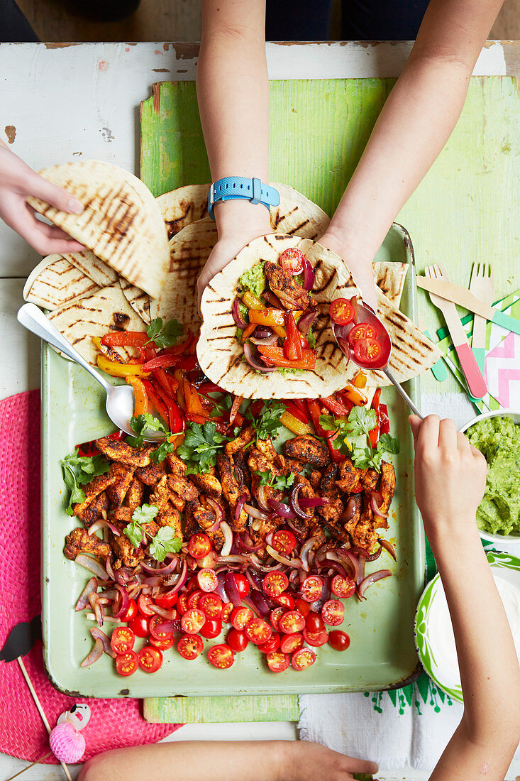 Kids preparing chicken fajitas