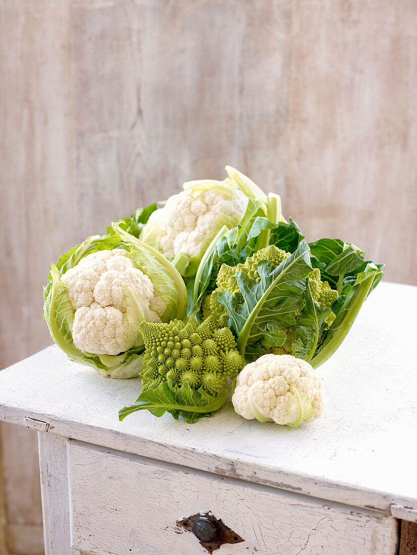 Blumenkohl und Romanesco auf Holztisch