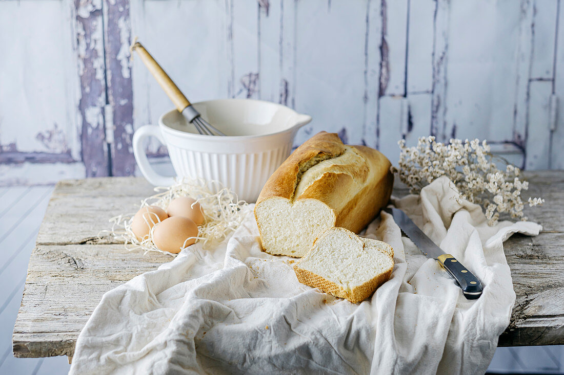 Brioche, angeschnitten auf Tuch und Holztisch