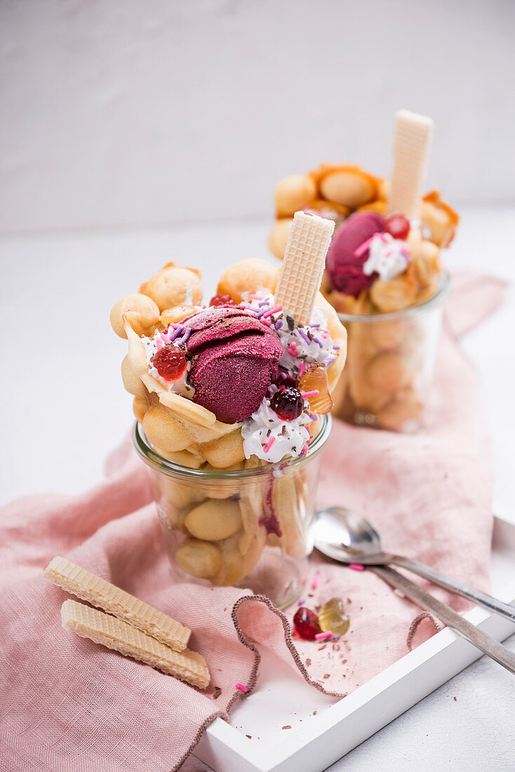 Vegan bubble waffles with blackcurrant sorbet, soya cream and colourful decorations