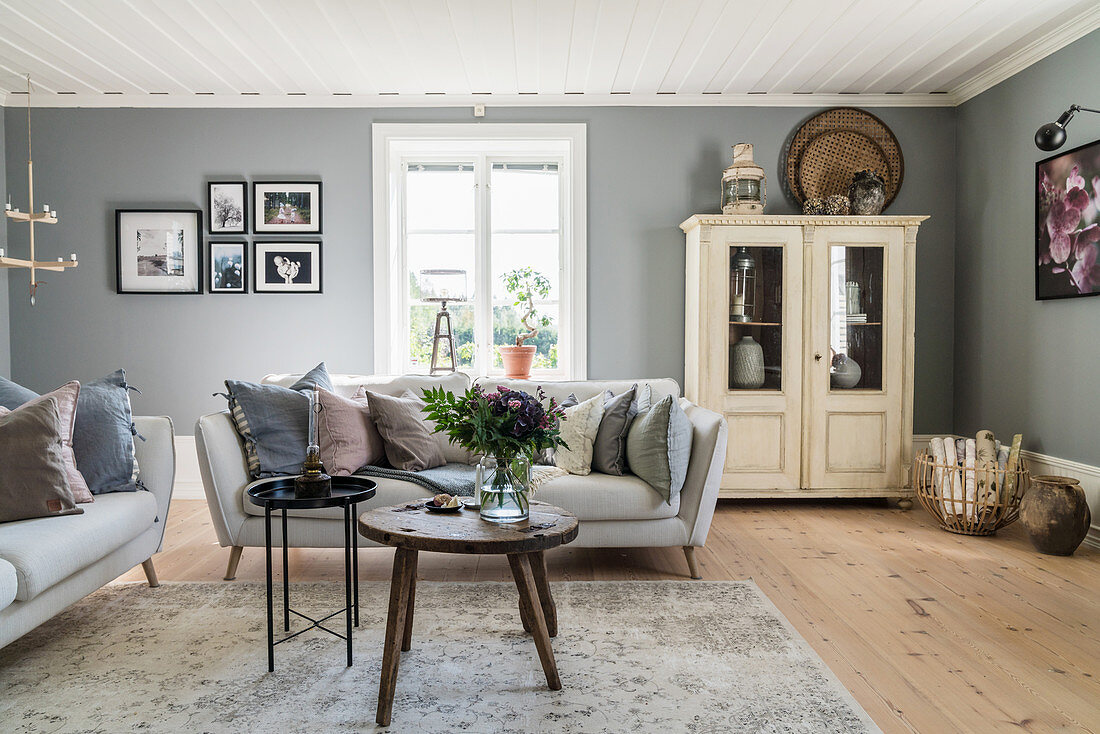 Mixture of old and new furnishings in living room with grey walls