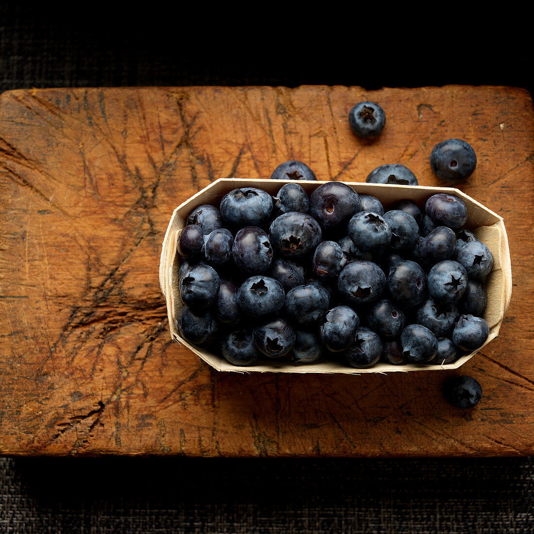 Blueberries in wooden tray on cutting board