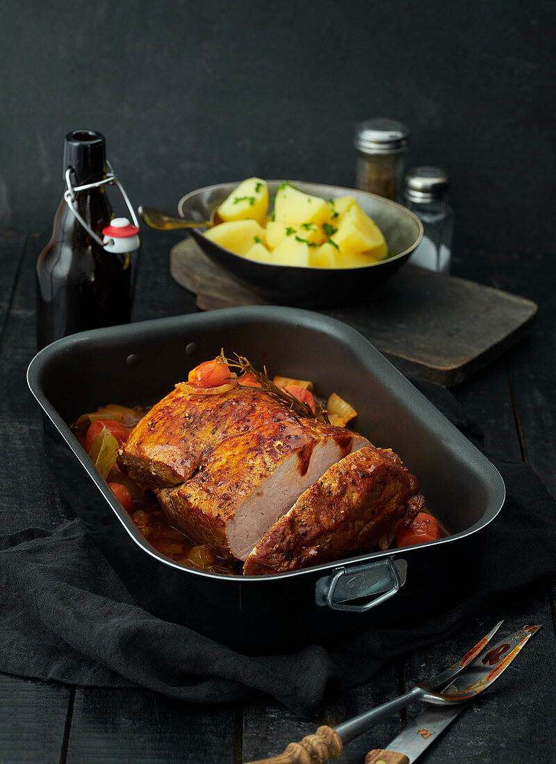 Roast pork in baking tin with parsley potatoes
