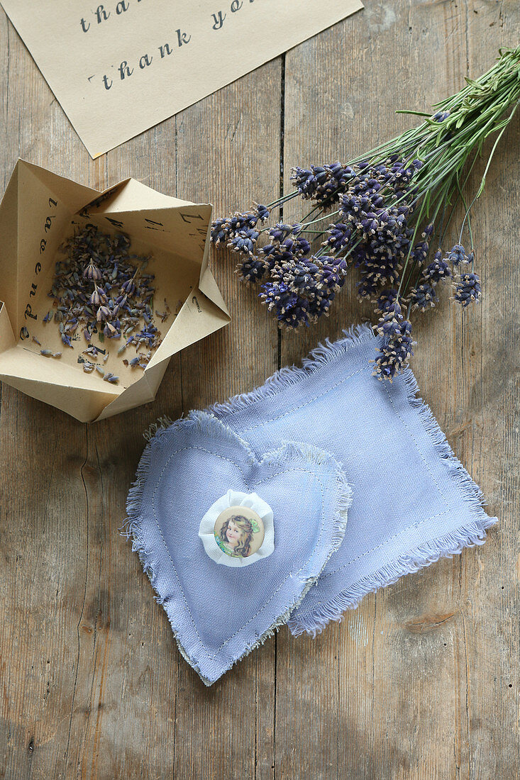 Selbstgemachte Lavendelsäckchen und gefaltete Papierschachteln mit Lavendelblüten