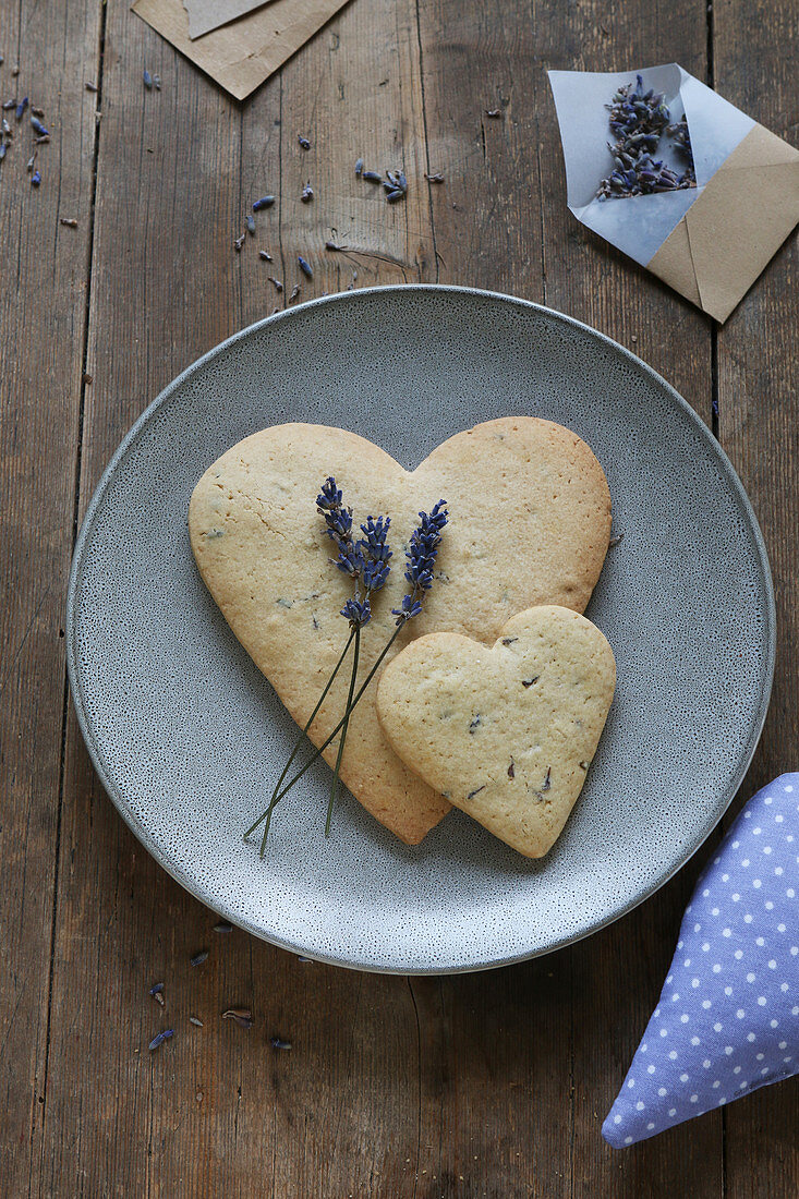 A heart-shaped, gluten-free lavender shortbread biscuit on a plate