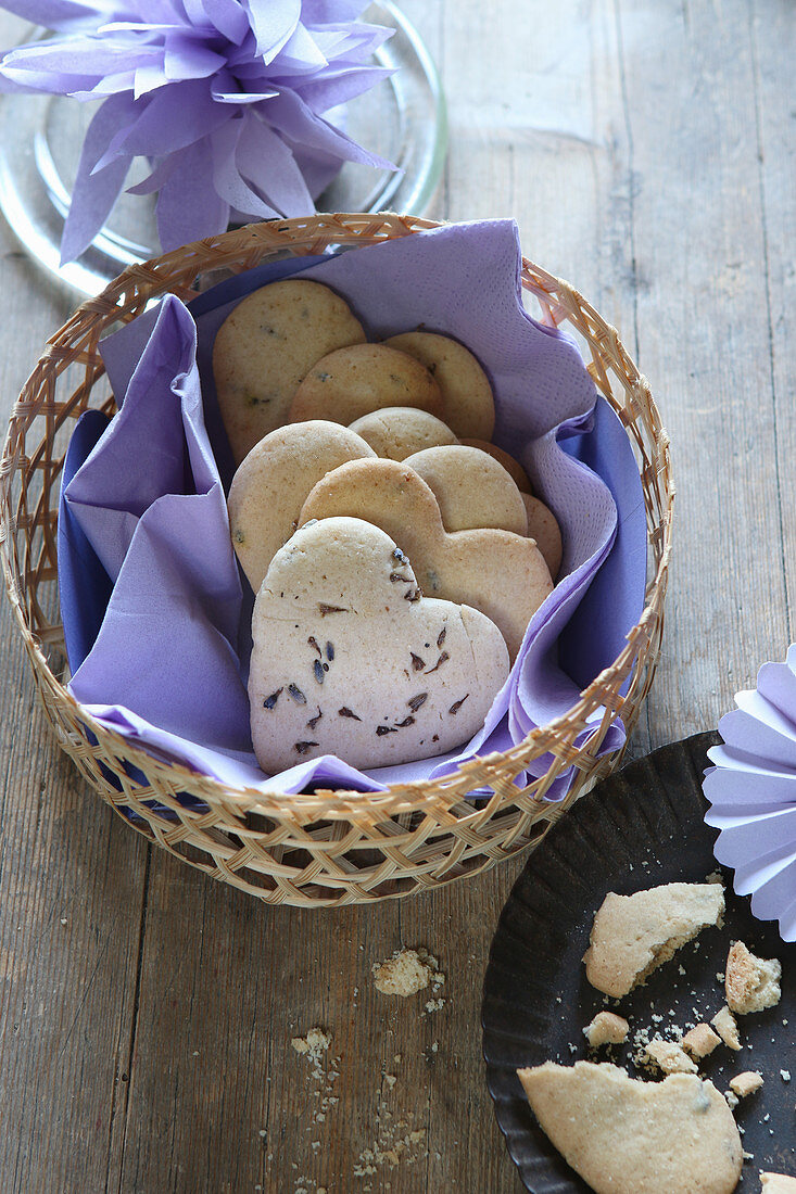 Heart-shaped, gluten-free lavender shortbread biscuits in a basket with a purple napkin