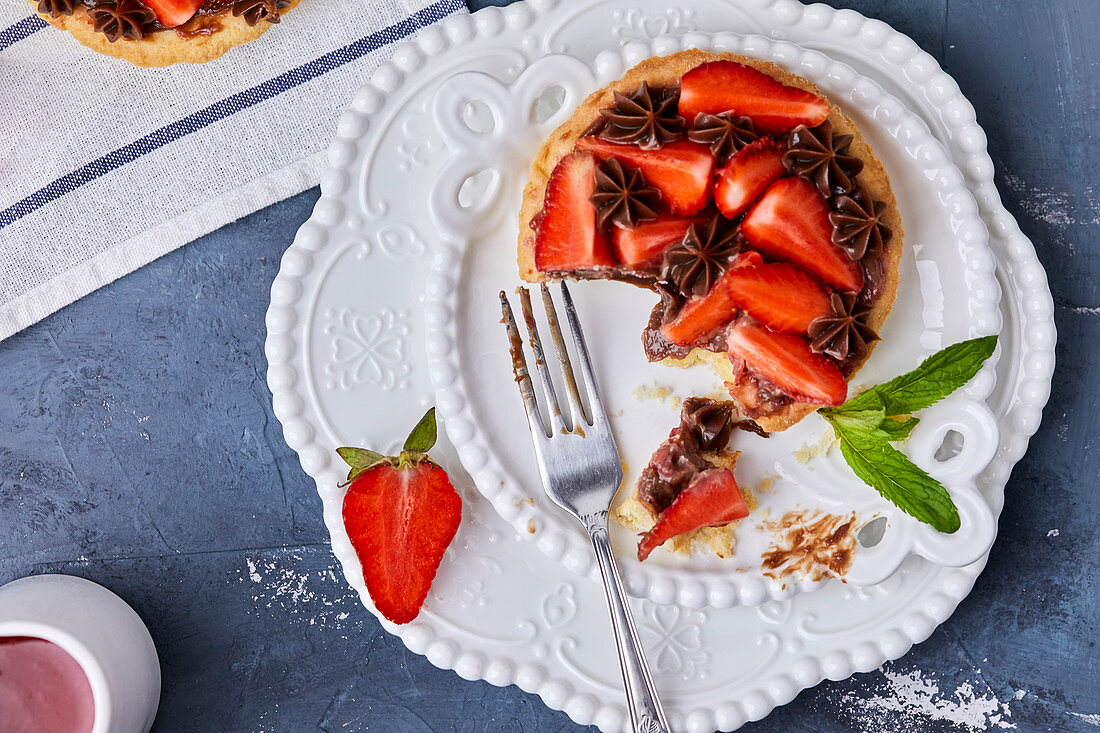 Erdbeertörtchen mit Marmelade und Schokoladenganache, angebissen