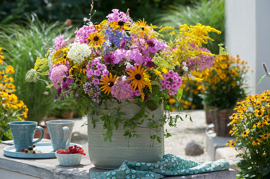 Colourful summer bouquet made of coneflower, goldenrod, flame flower, hydrangea, widow flower and clematis