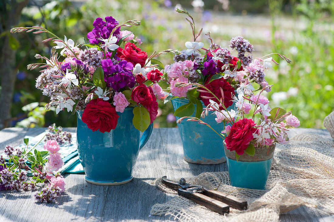 Summer bouquets of roses, candle, flame flower and oregano flowers