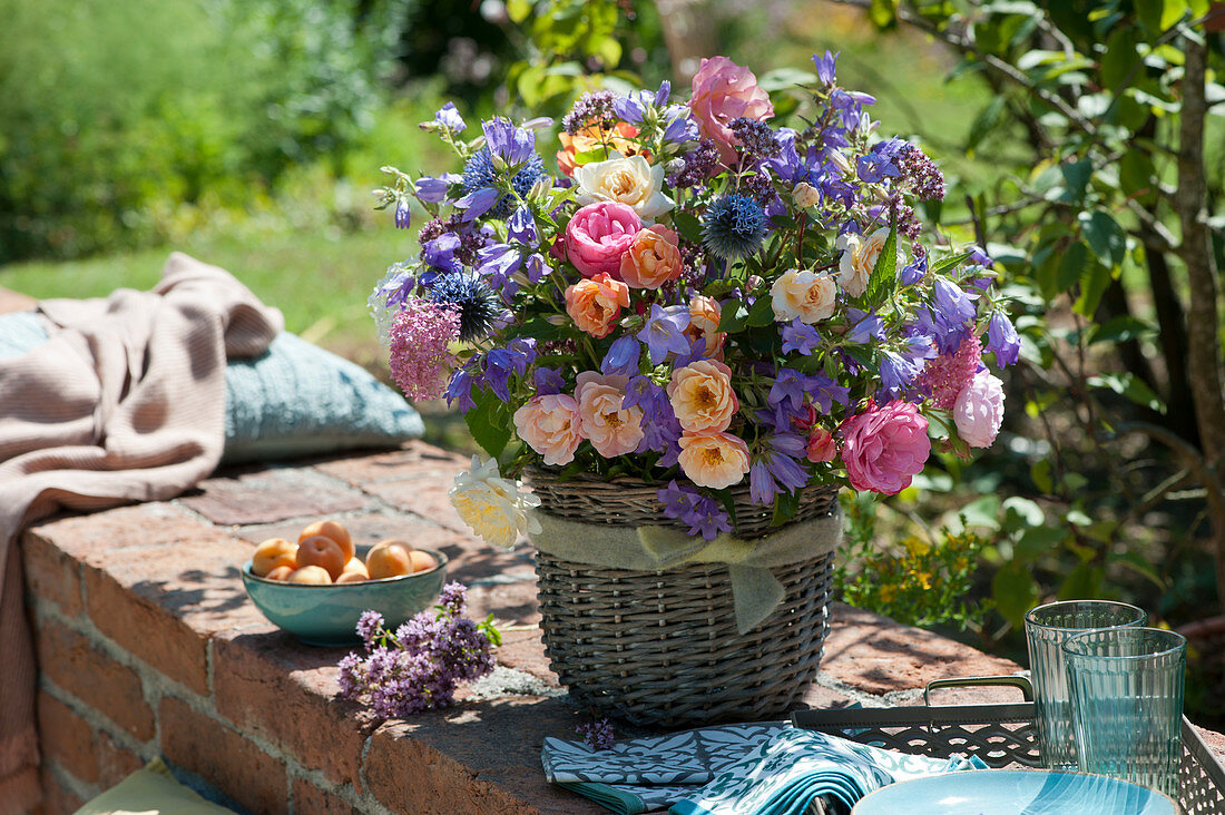 Lush summer bouquet of roses, cranesbill, bluebells, spur flowers, thistle and oregano flowers