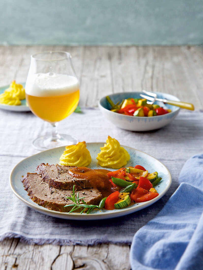 Beer-soaked roast beef with parmesan potatoes and vegetables