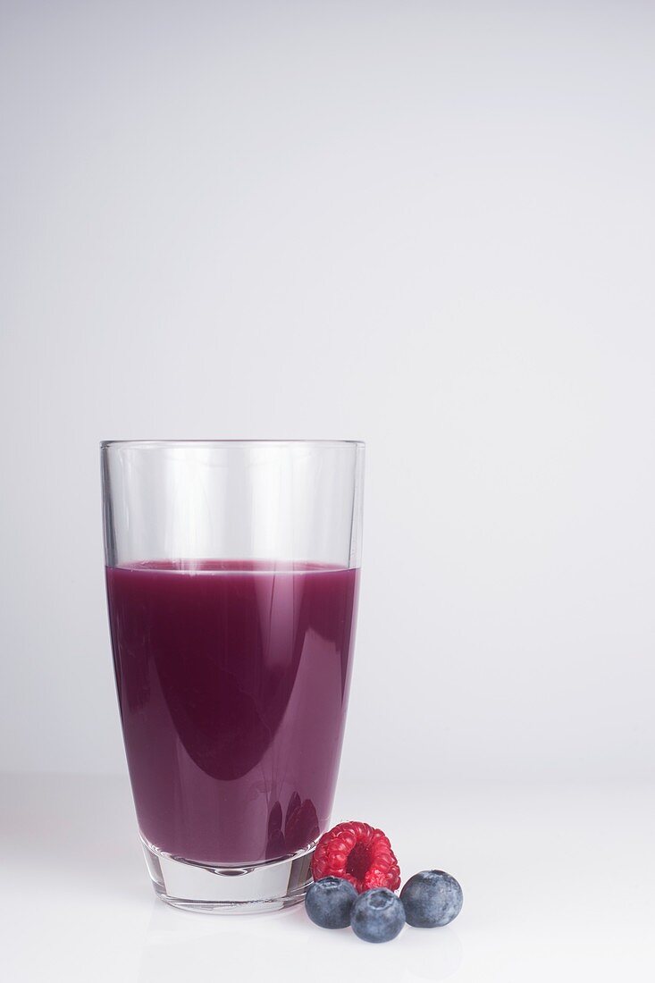A glass of fresh juice made with mixed berries