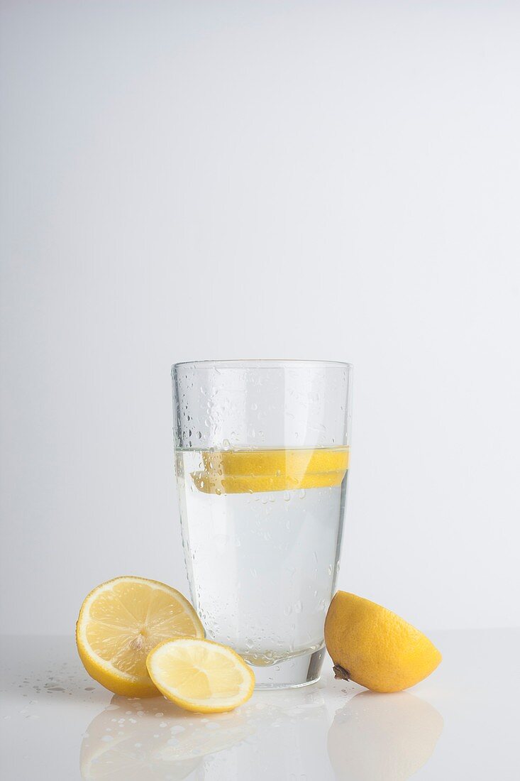 A glass of water with fresh lemon slices