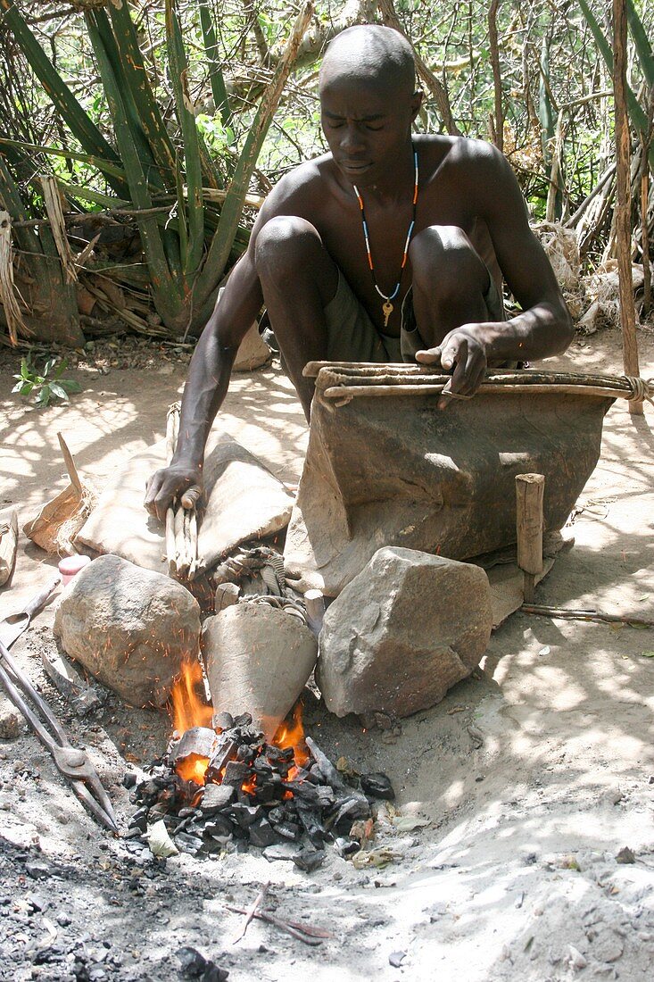 Datoga blacksmith lighting a fire