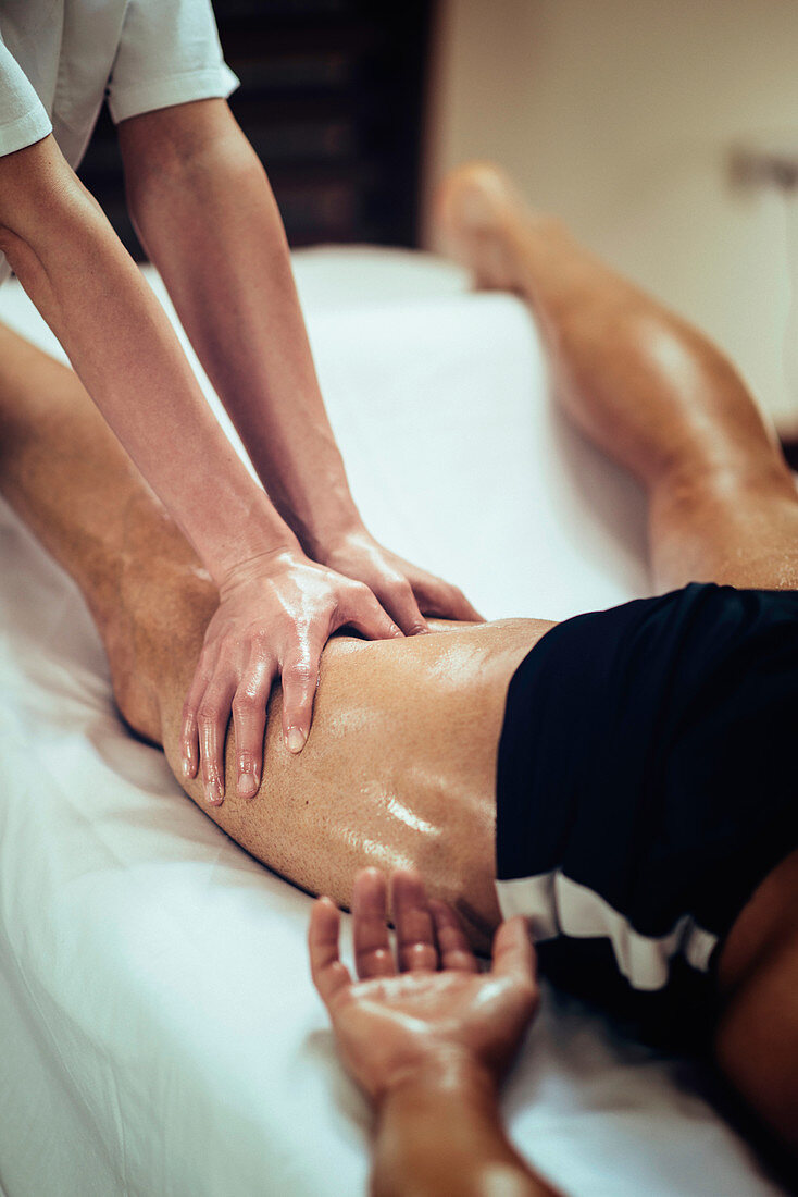 Physical therapist massaging leg