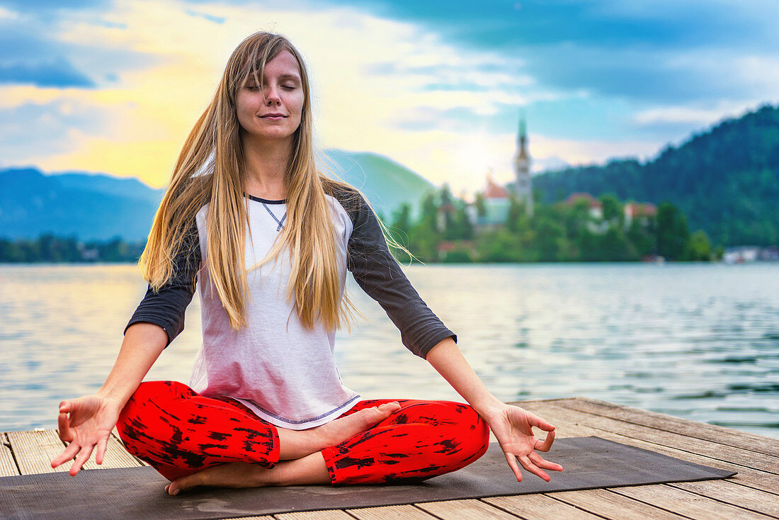 Woman doing yoga by a lake