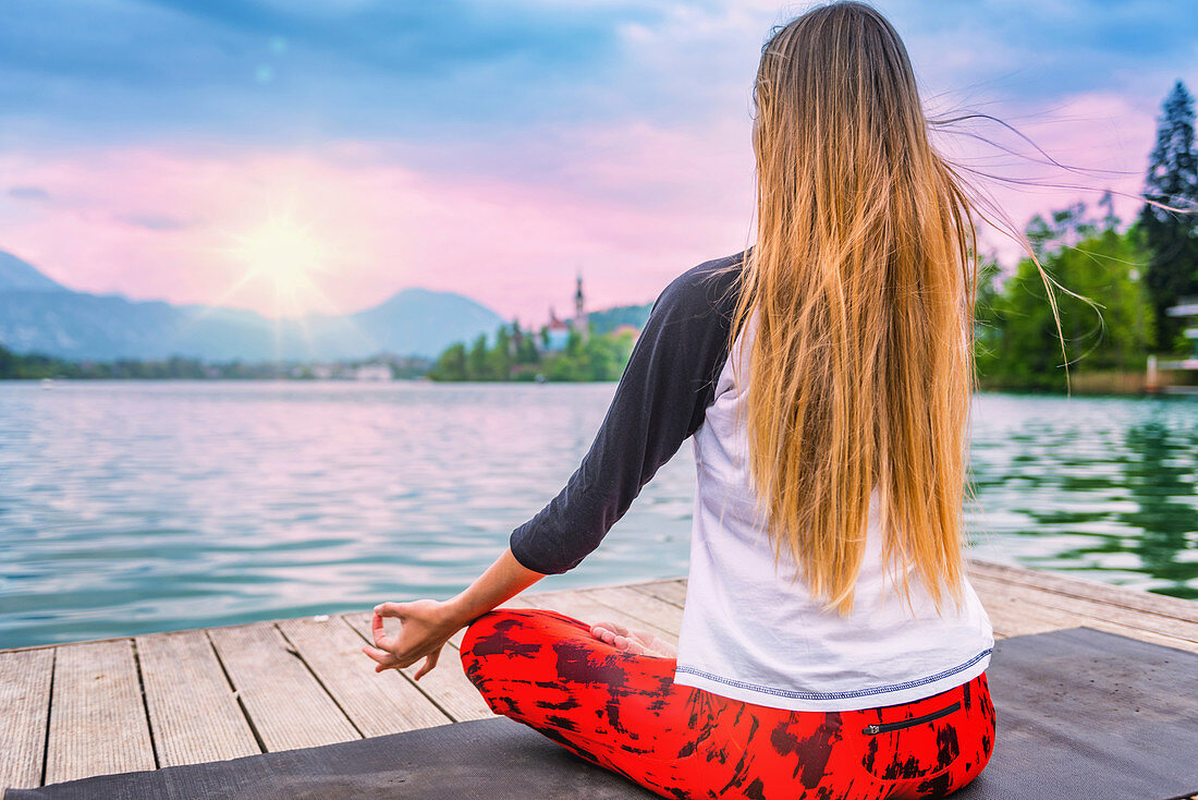 Woman doing yoga by a lake