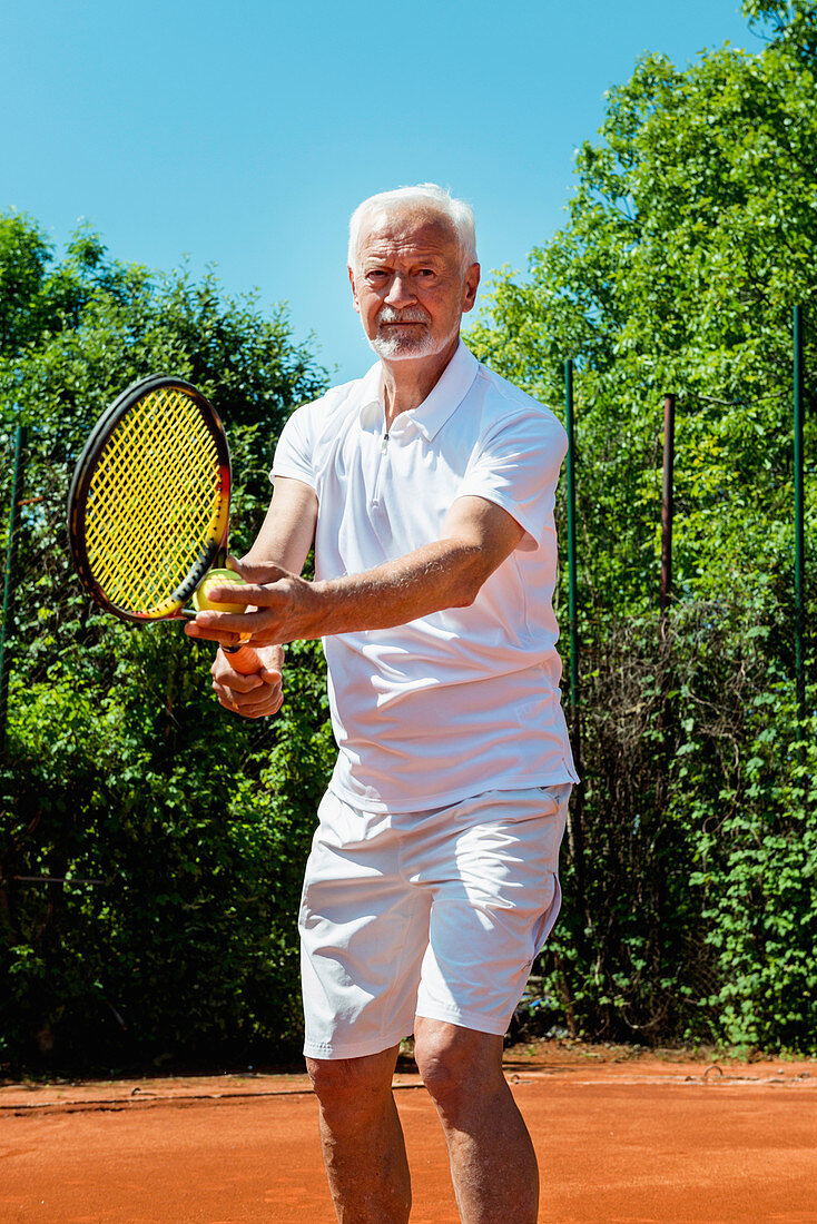 Senior tennis player serving