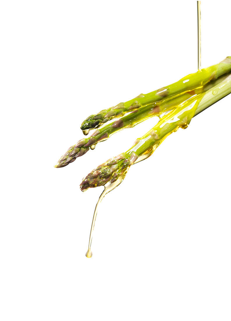 Oil pouring on asparagus spears