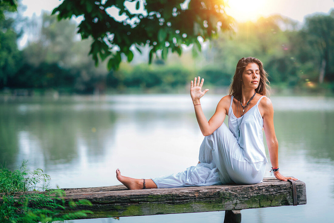 Woman doing yoga by a lake