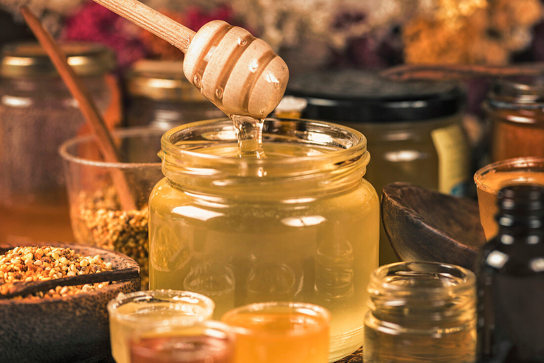 Honey flowing into a glass jar
