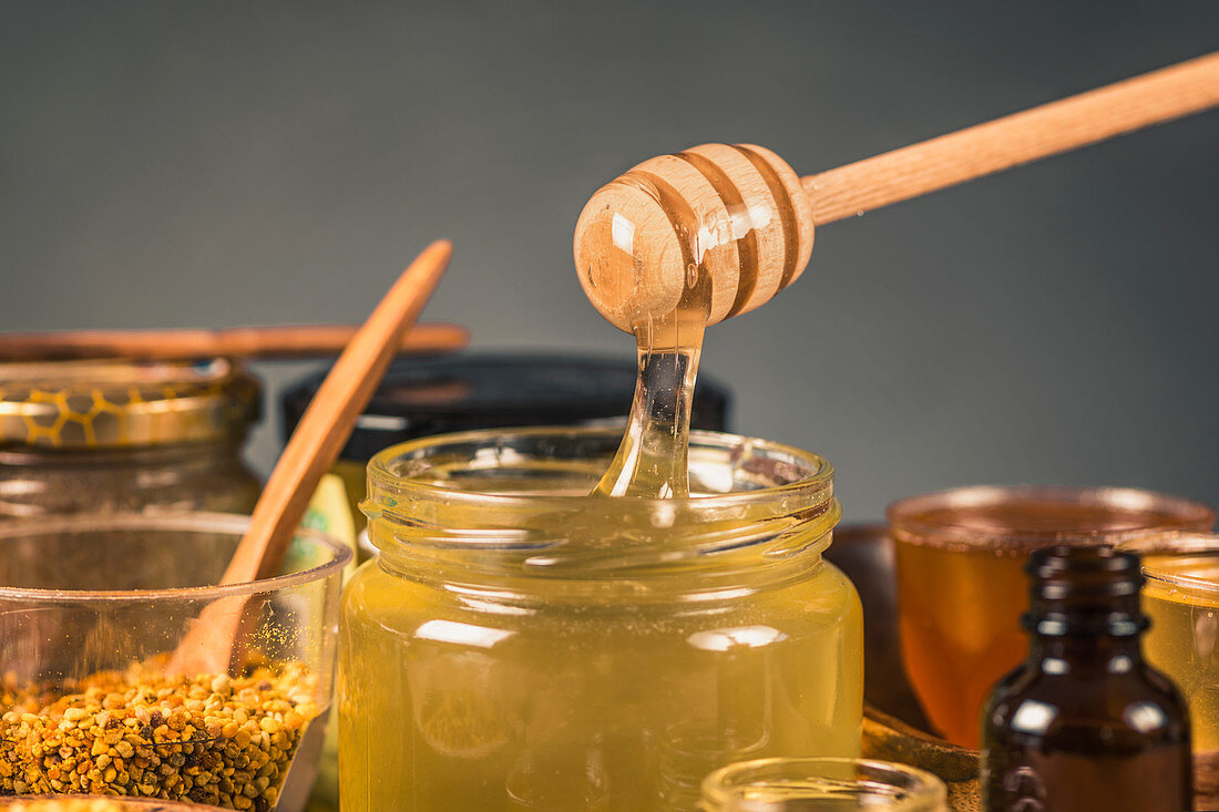 Honey flowing into a glass jar