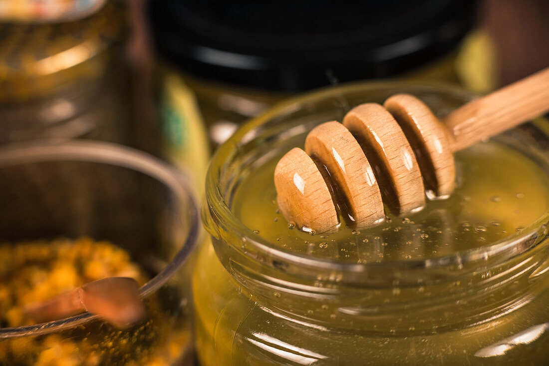 Honey glass jar with wooden dipper