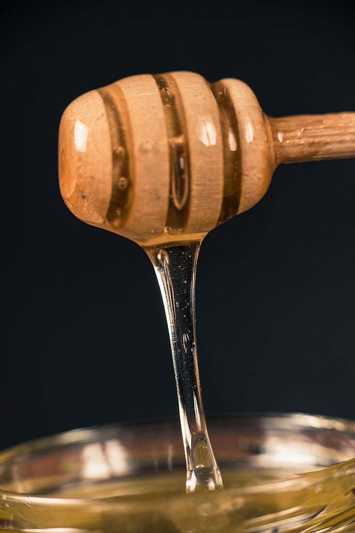 Wooden dipper with flowing honey