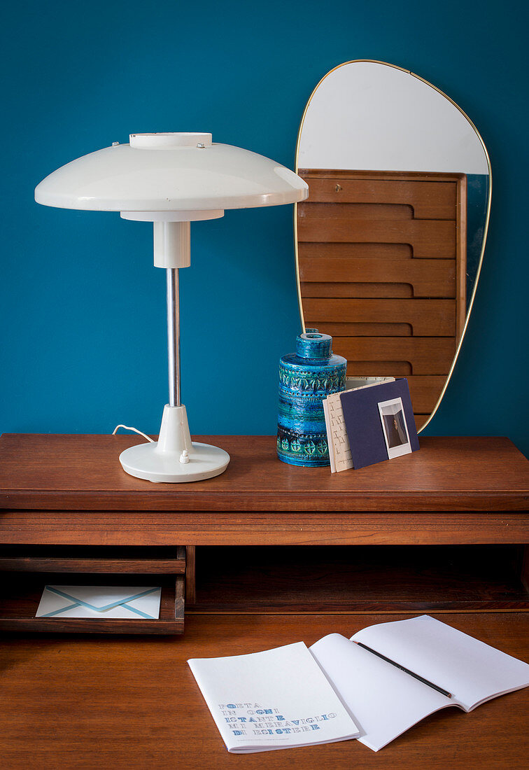 Table lamp and retro mirror on dark wooden desk