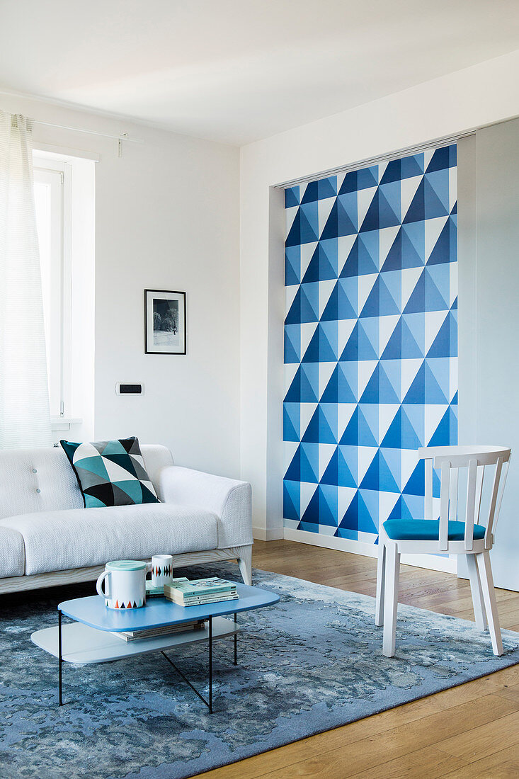 Decorative blue-and-white geometric pattern behind sliding wall in living area
