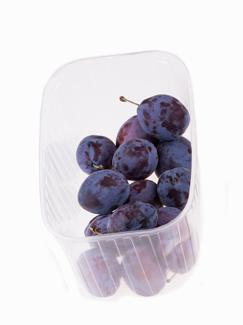 Fresh plums in plastic punnet