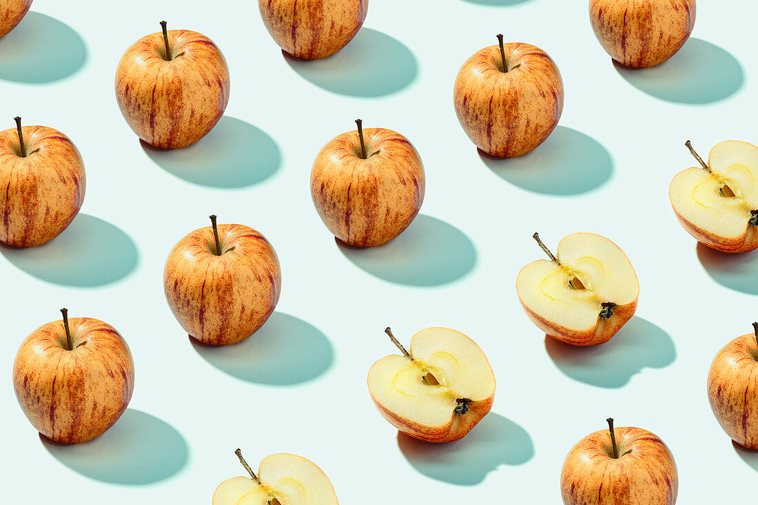 Red and orange apples on white surface