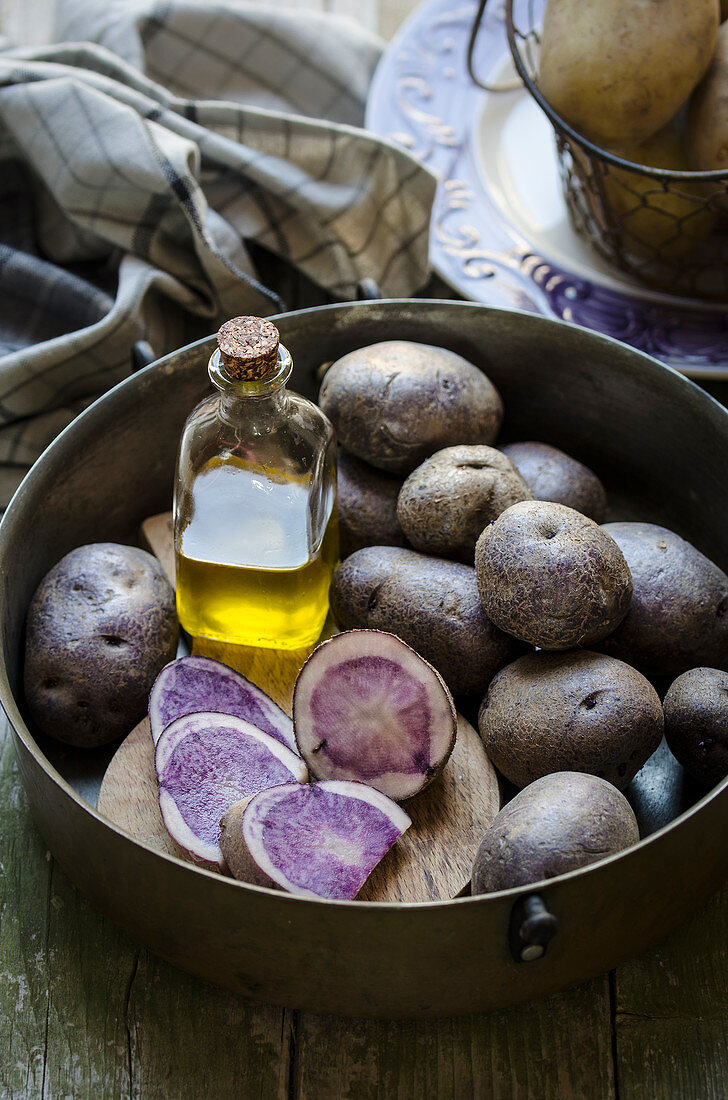 Lila Kartoffeln und Flasche Olivenöl