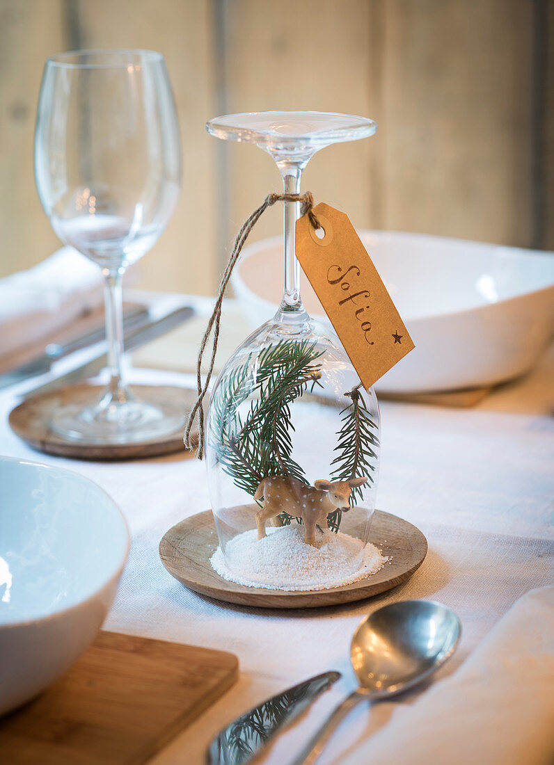 DIY place card with winter landscape under upturned wine glass