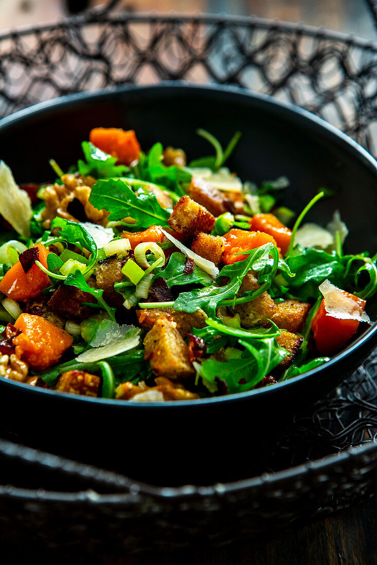 An autumnal salad with caramelised pumpkin, rocket, walnuts, bacon and croutons