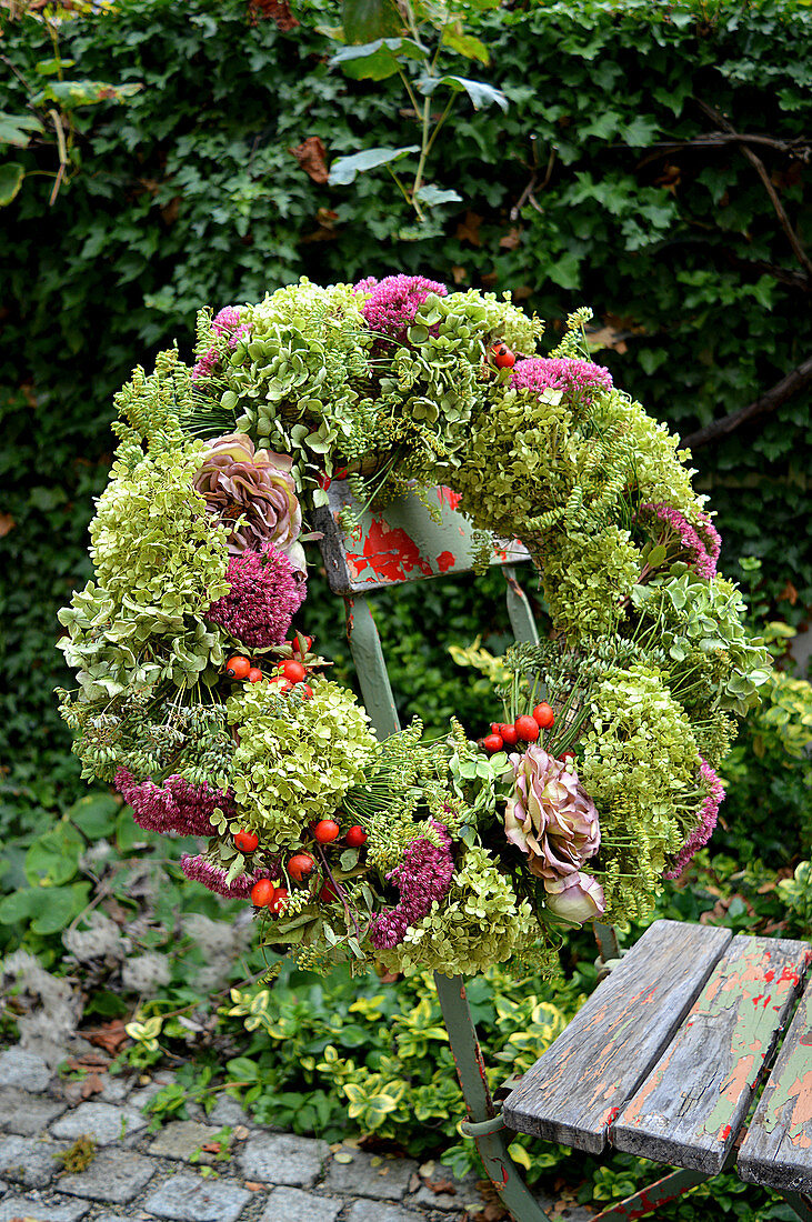 Autumn wreath with sedum plant, hydrangea, fennel, rose blossoms, and rose hips