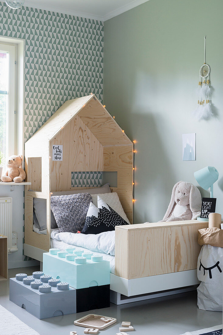 Steps made from oversize Lego bricks leading to bed with house-shaped canopy in child's bedroom