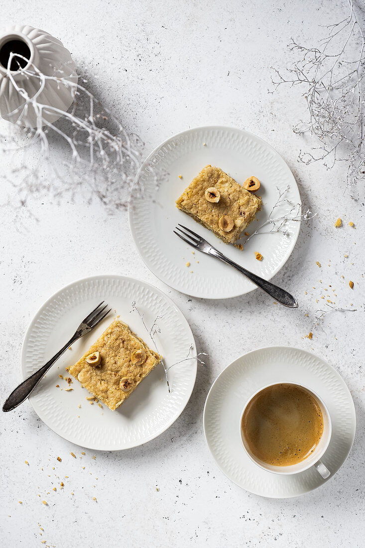 Gluten-free blondie with hazelnut served on white plates with coffee