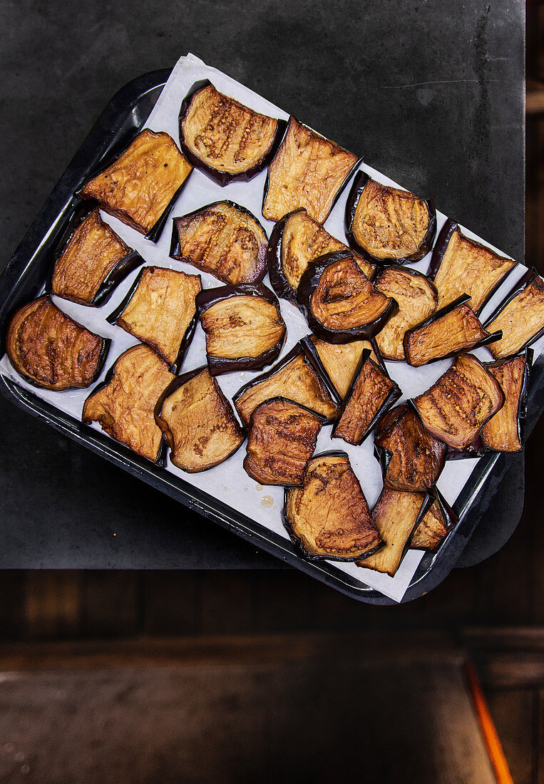 Fried aubergine slices on a baking tray